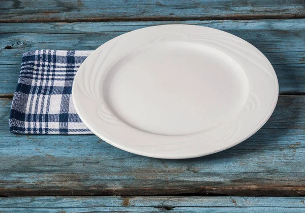 Placa vazia com guardanapo na mesa de madeira azul — Fotografia de Stock