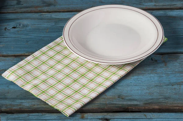 Άδειο πιάτο με χαρτοπετσέτα σε μπλε ξύλινο τραπέζι — Φωτογραφία Αρχείου