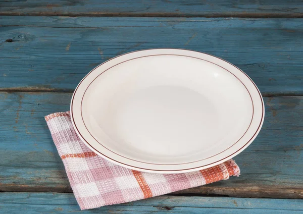 Leerer Teller mit Serviette auf blauem Holztisch — Stockfoto