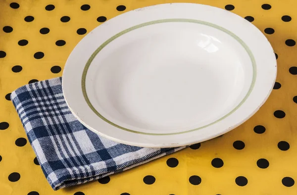 White plate on light yellow polka dot background — Stock Photo, Image