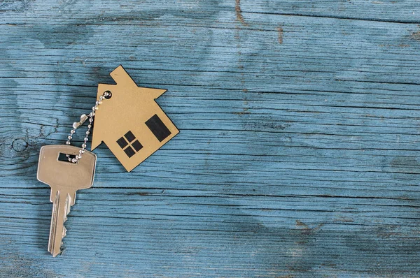 与老式的木制背景上的银钥匙房子的象征 — 图库照片
