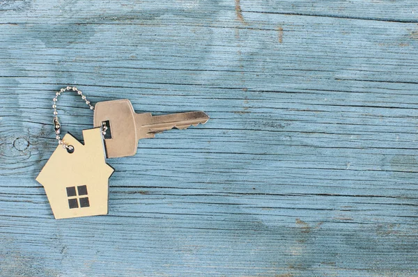 Símbolo de la casa con llave de plata sobre fondo de madera vintage —  Fotos de Stock