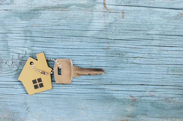 Symbole de la maison avec clé argent sur fond bois vintage — Photo