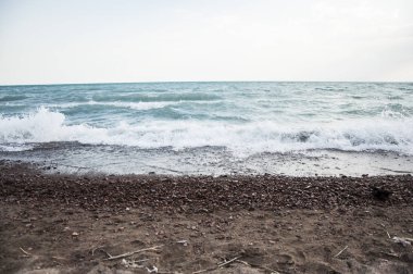 Bir çakıl taşı kumsalında el salla