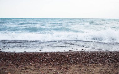 Bir çakıl taşı kumsalında el salla