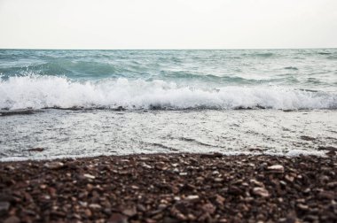 Bir çakıl taşı kumsalında el salla