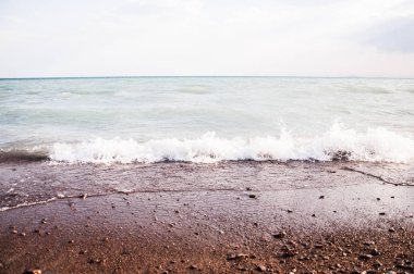 Bir çakıl taşı kumsalında el salla