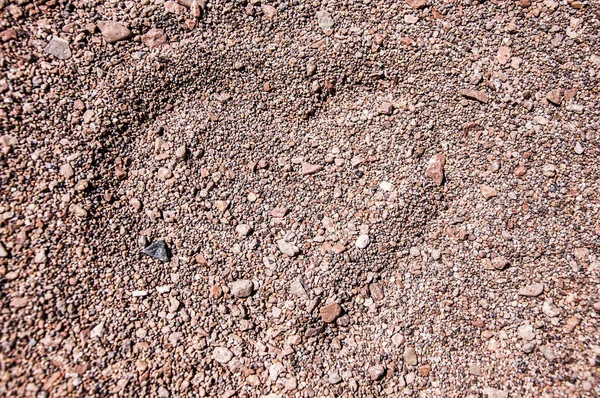 Hjärtat består av småsten på sand bakgrund — Stockfoto