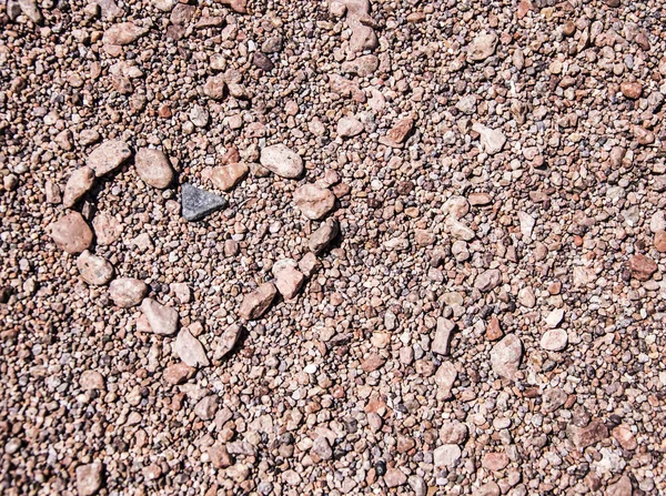 Herz aus Kieselsteinen auf Sandgrund — Stockfoto