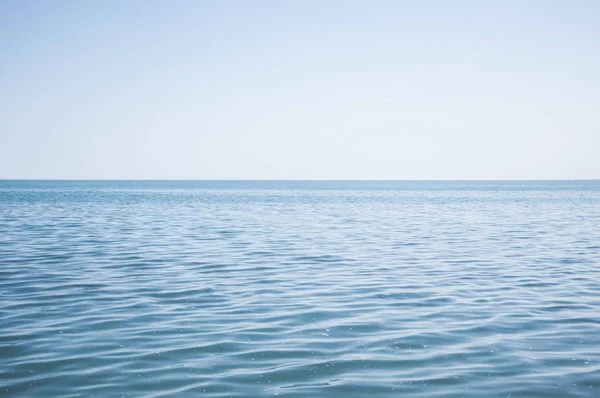 Blauwe zee en wolken aan de hemel — Stockfoto