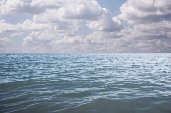 Blauwe zee en wolken aan de hemel — Stockfoto