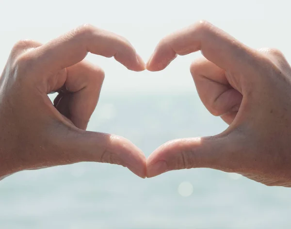 Heart from hands on sea-view — Stock Photo, Image