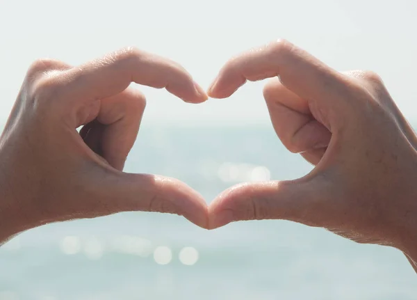 Heart from hands on sea-view — Stock Photo, Image