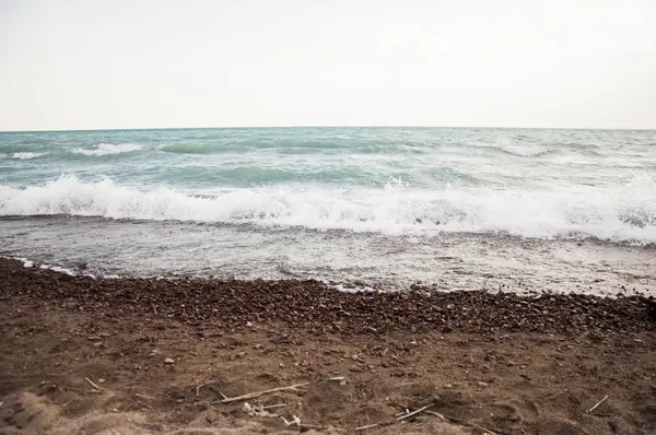 Bir çakıl taşı kumsalında el salla