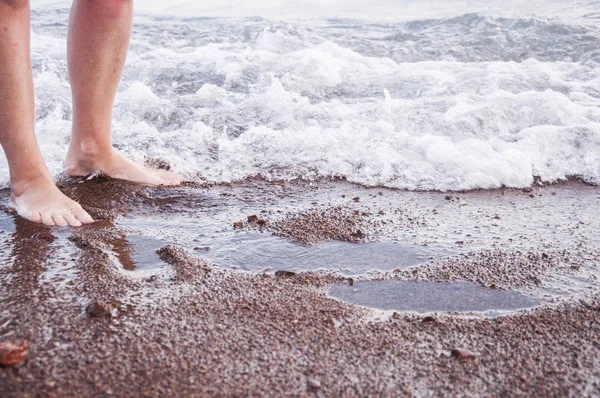 Belle femme jambes sur la plage au coucher du soleil — Photo