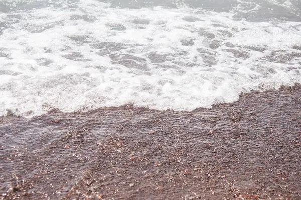 Sea wave och pebble beach — Stockfoto