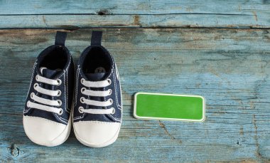 Tahta arka planda bebek ayakkabıları