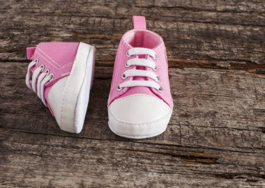 Tahta arka planda bebek ayakkabıları