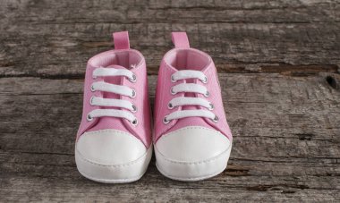 Tahta arka planda bebek ayakkabıları