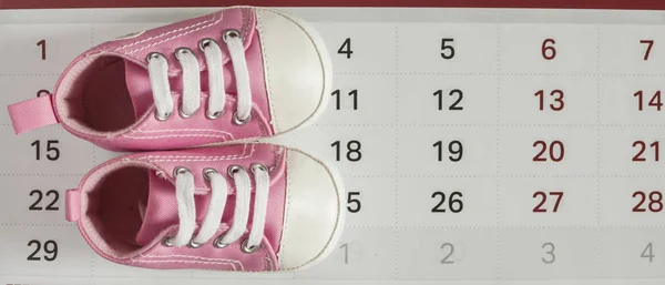 Маленькие детские туфли с календарем — стоковое фото
