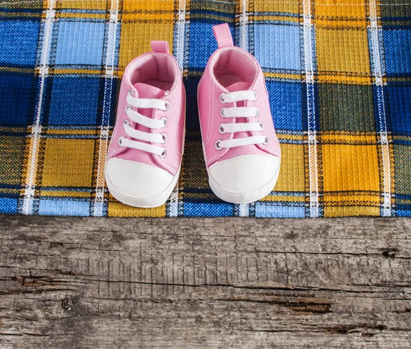 木製の背景に赤ちゃんの靴 — ストック写真