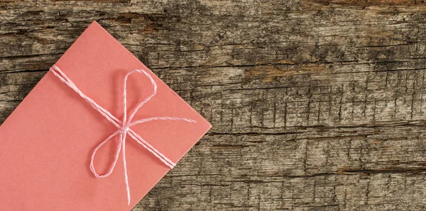 Envelope amarrado com fita em fundo de madeira — Fotografia de Stock