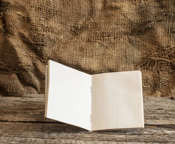 Notebook in een kooi op een houten achtergrond — Stockfoto