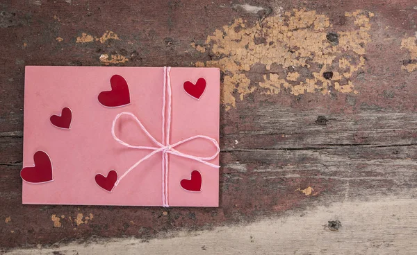 Cuori rossi e rosa busta su sfondo di legno — Foto Stock