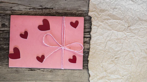 Sobre rosa y pequeño corazón en la mesa de madera para el Día de San Valentín — Foto de Stock