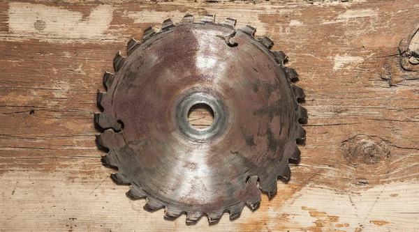 Metal saw blade on a wooden background — Stock Photo, Image