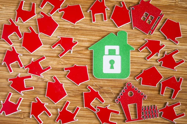 Σύμβολο πολλά κόκκινο σπίτι σε ξύλινα φόντο. Αντίληψη ακινήτων — Φωτογραφία Αρχείου