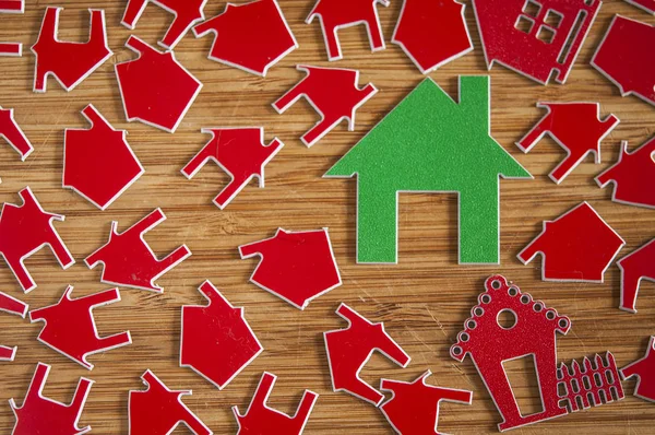 Muitos símbolo de casa vermelho no fundo de madeira. Conceito imobiliário — Fotografia de Stock