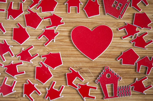 Muitos símbolo de casa vermelho no fundo de madeira. Conceito imobiliário — Fotografia de Stock
