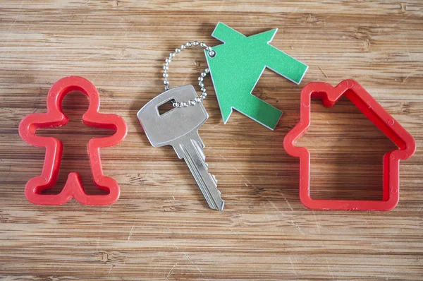 Männerfigur mit einem Haus auf Holzgrund — Stockfoto