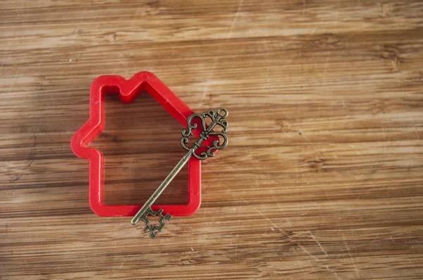 Σύμβολο του σπιτιού με ασημένιο κλειδί σε εκλεκτής ποιότητας ξύλινα φόντο — Φωτογραφία Αρχείου