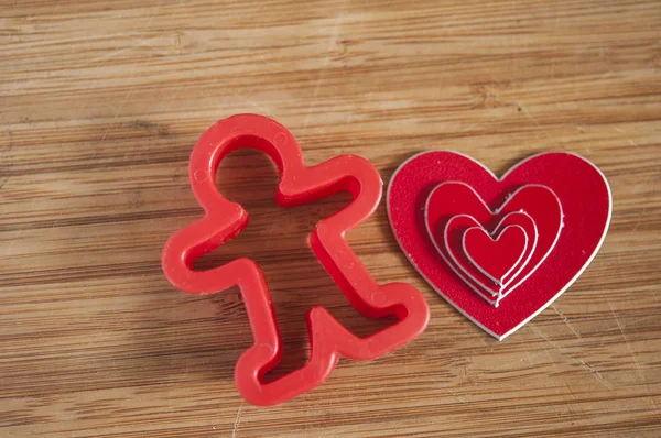 Man figure presenting and showing heart on wooden background — Stock Photo, Image