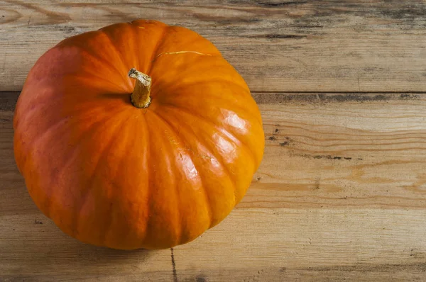 Ahşap arka plan üzerinde büyük sarı kabak.