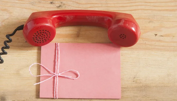 Receptor de telefone antiquado vermelho na mesa de madeira — Fotografia de Stock