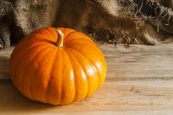 Ahşap arka plan üzerinde büyük sarı kabak.