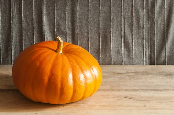 Ahşap arka plan üzerinde büyük sarı kabak.