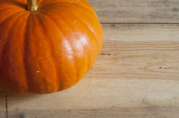 Ahşap arka plan üzerinde büyük sarı kabak.