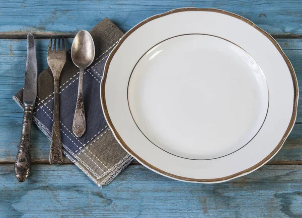 Cerrar cuchara, tenedor y cuchillo en plato blanco — Foto de Stock