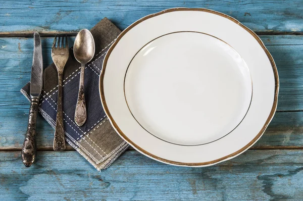 Cerrar cuchara, tenedor y cuchillo en plato blanco — Foto de Stock