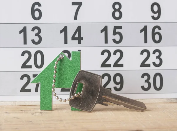 Símbolo de la casa con llave de plata sobre fondo de madera vintage —  Fotos de Stock