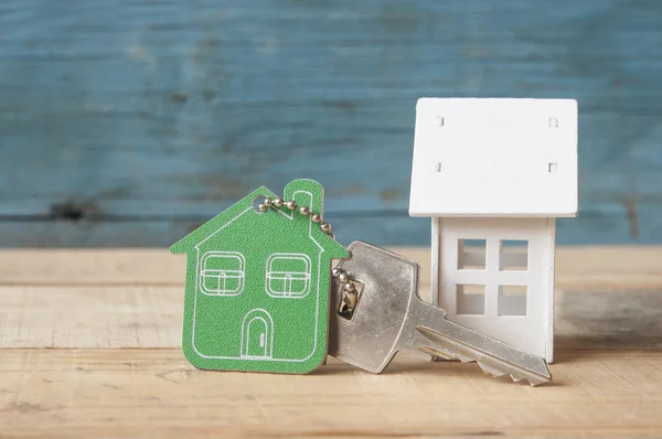 Symbol of the house with silver key on vintage wooden background — Stock Photo, Image