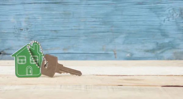 Símbolo de la casa con llave de plata sobre fondo de madera vintage — Foto de Stock