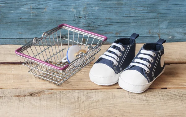 Babyschuhe und Einkaufskorb — Stockfoto