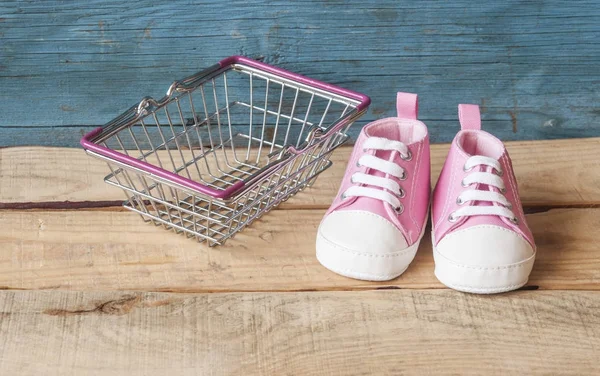 Buty dziecięce i kosz na zakupy — Zdjęcie stockowe