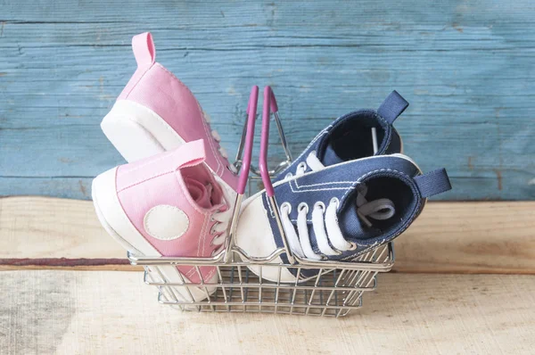 Baby shoes and shopping basket — Stock Photo, Image