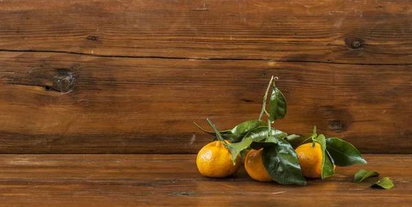 木製の背景の緑の葉と新鮮なマンダリン オレンジ — ストック写真